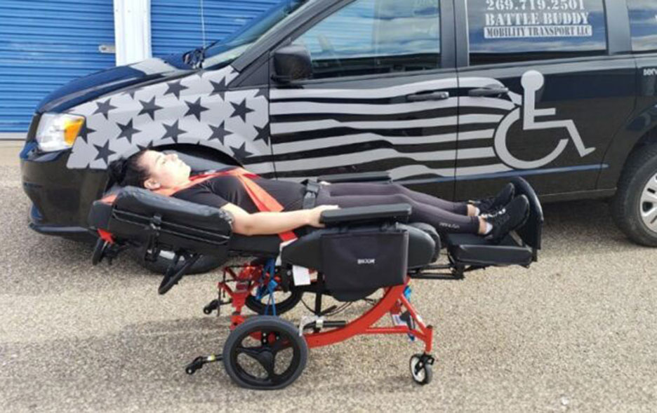 Broda chair in a lay-down position next to a Battle Buddy NEMT vehicle