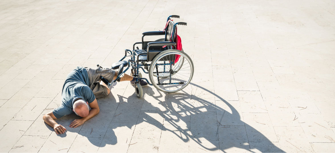 Staged Image of A Man Whos Fallen Out Of A Wheelchair