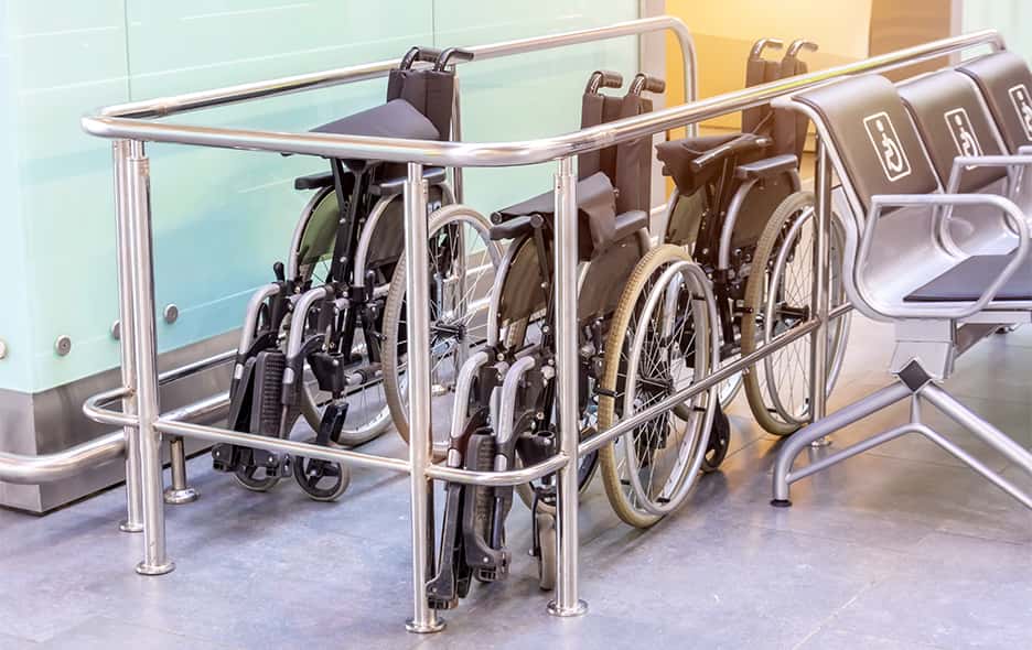 Standard wheelchairs folded in a parking corral