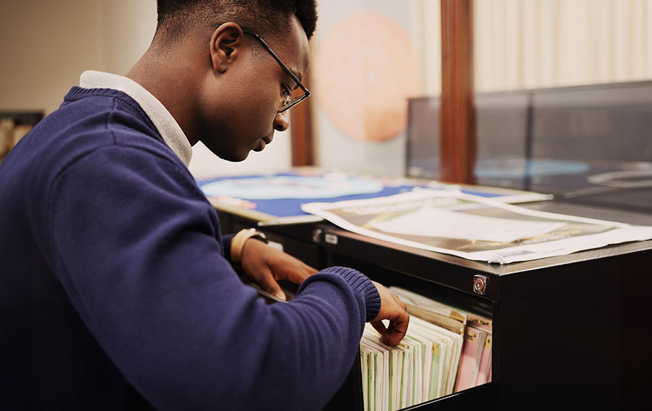 Young man sifting through company files