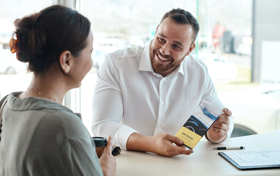 Two people discussing an NEMT business over a pamphlet